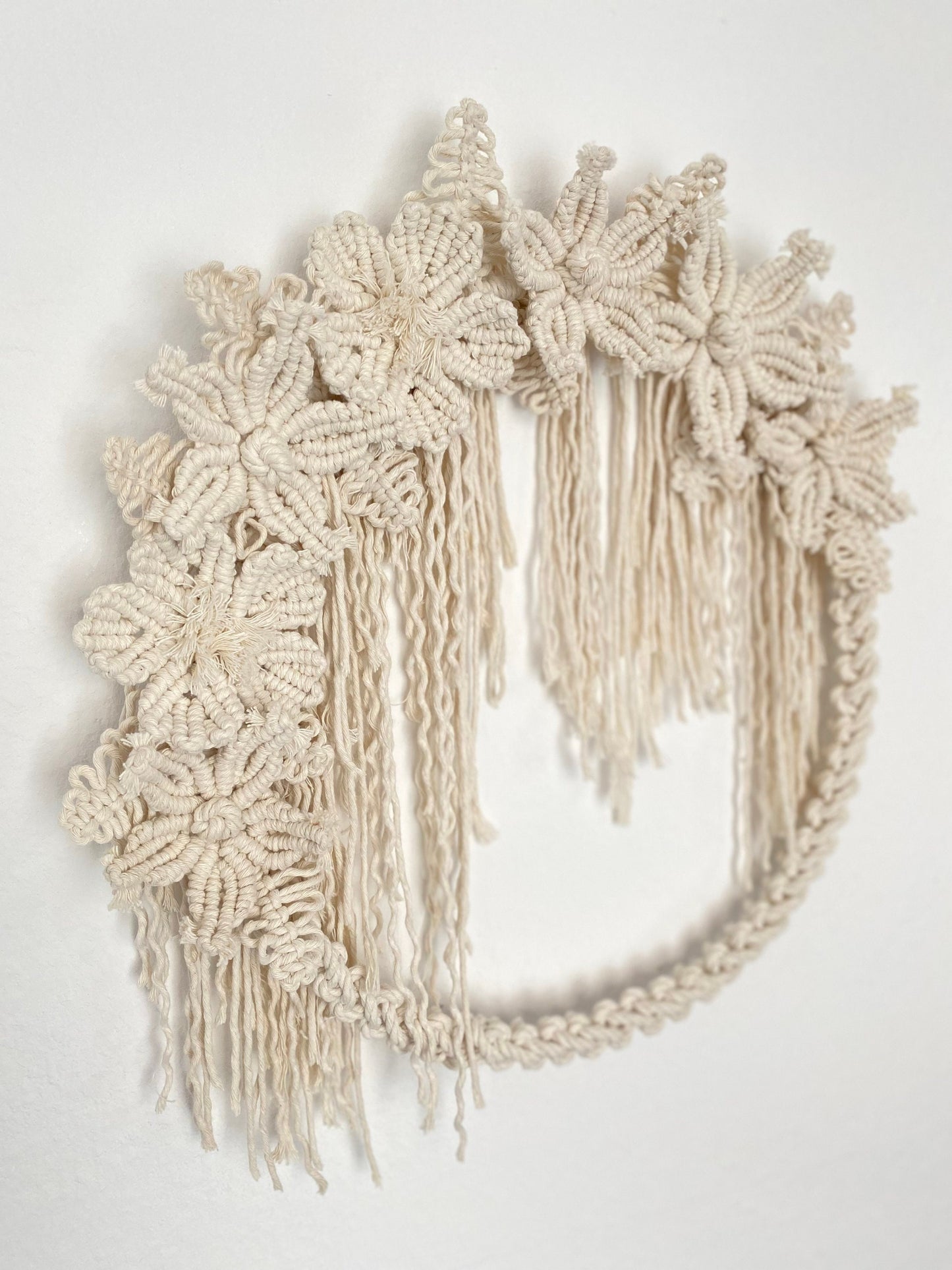 Macrame belt with floral designs and fringes on a white background