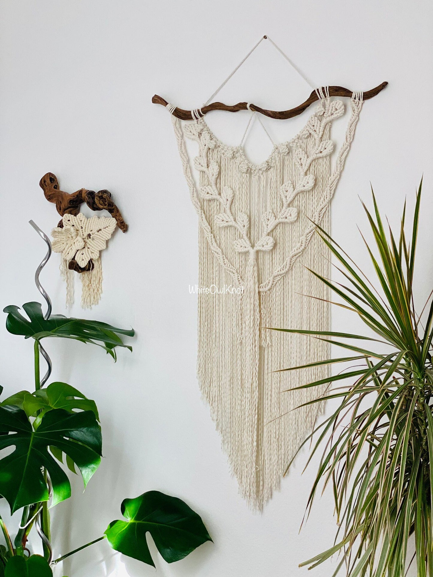 Macrame wall hanging with plants on a white wall