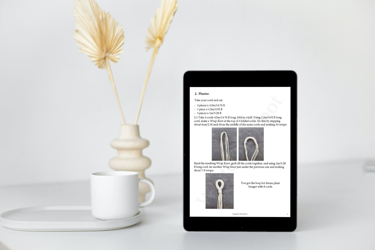 Digital tablet displaying a document on a white surface with decorative elements