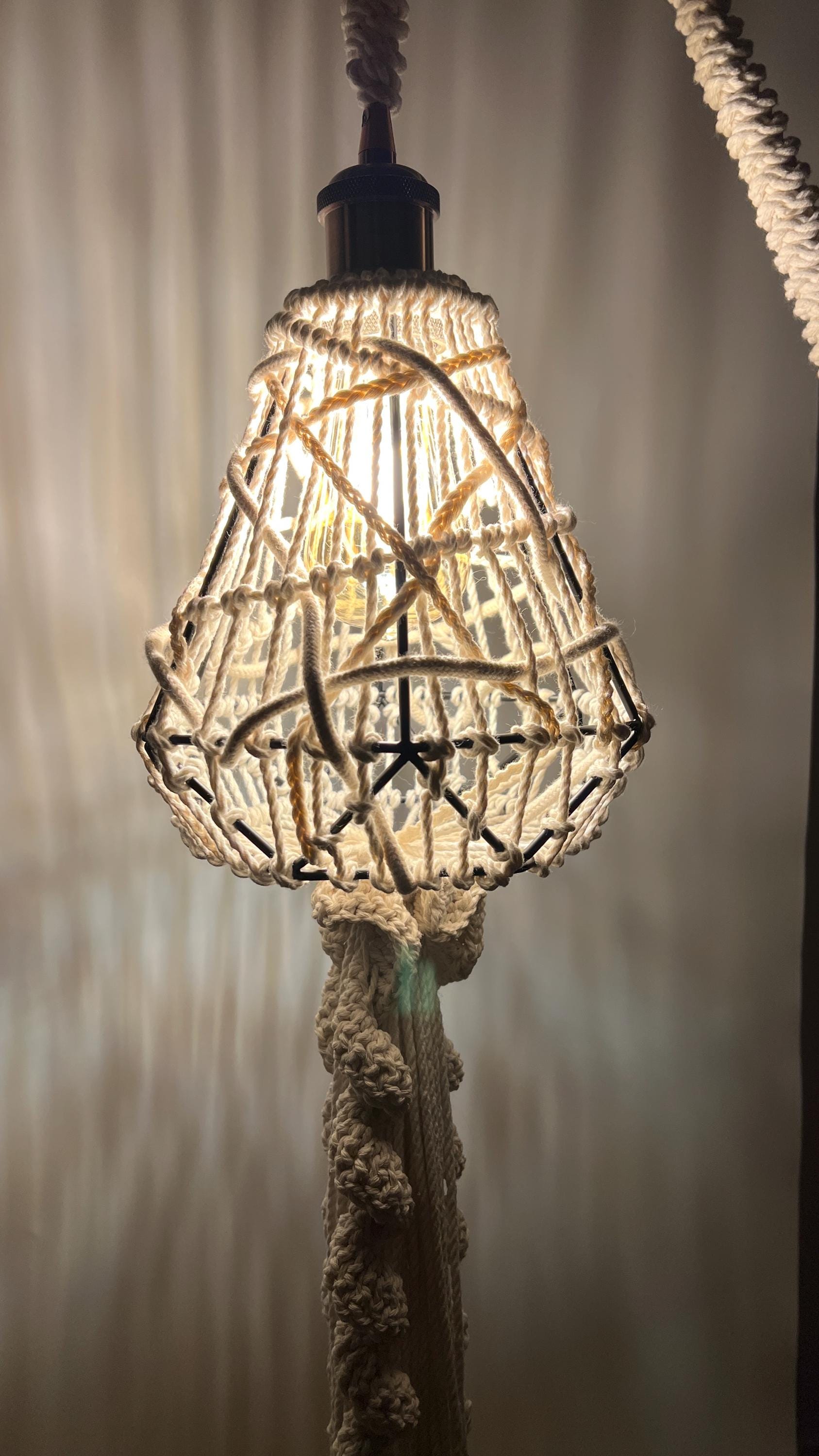 Decorative lampshade with woven design hanging against a neutral background