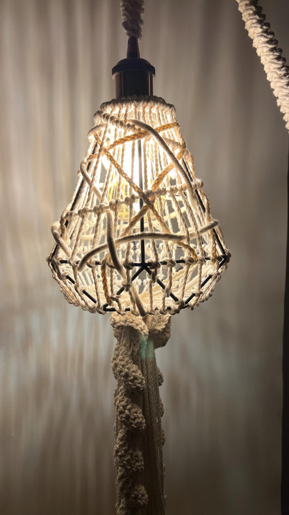 Decorative lampshade with woven design hanging against a neutral background
