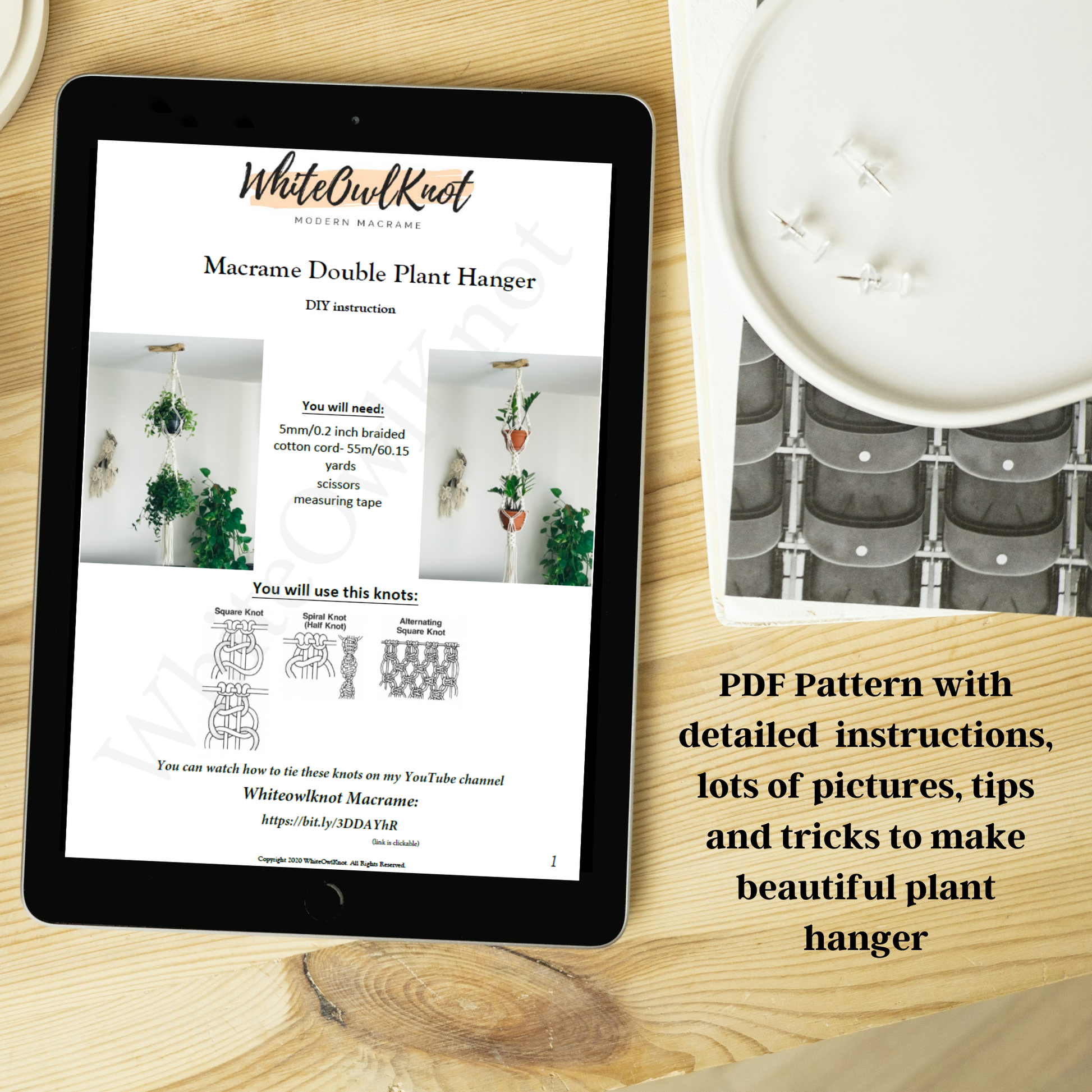 Tablet displaying a PDF pattern for a macrame double plant hanger on a wooden surface with a candle.