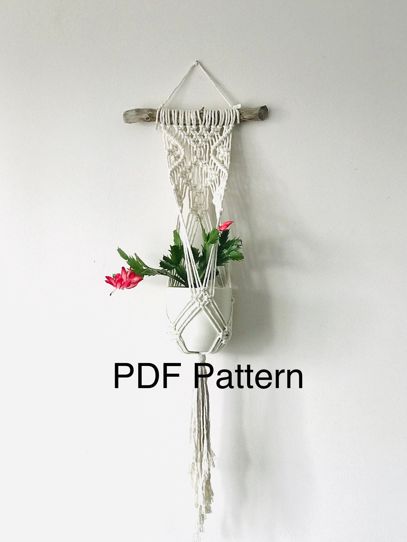Macrame plant hanger with flowers on a white background, labeled 'PDF Pattern'.