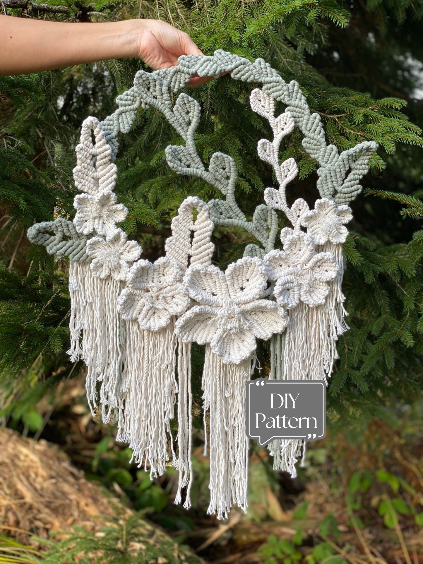 Handmade macrame wall hanging with floral designs and tassels against a natural background.