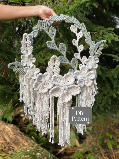 Handmade macrame wall hanging with floral designs and tassels against a natural background.
