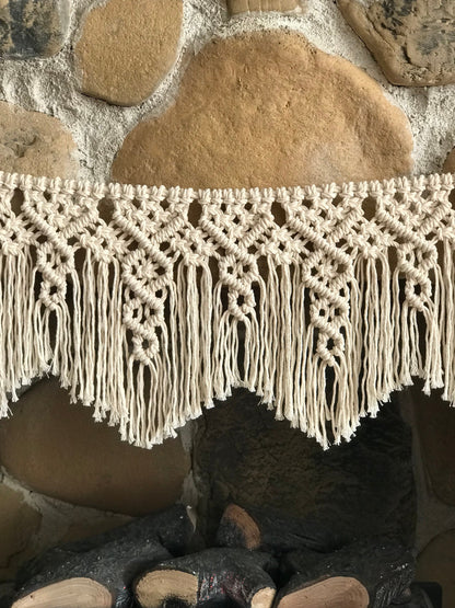 Close-up of a macrame garland's fringe against a stone wall background