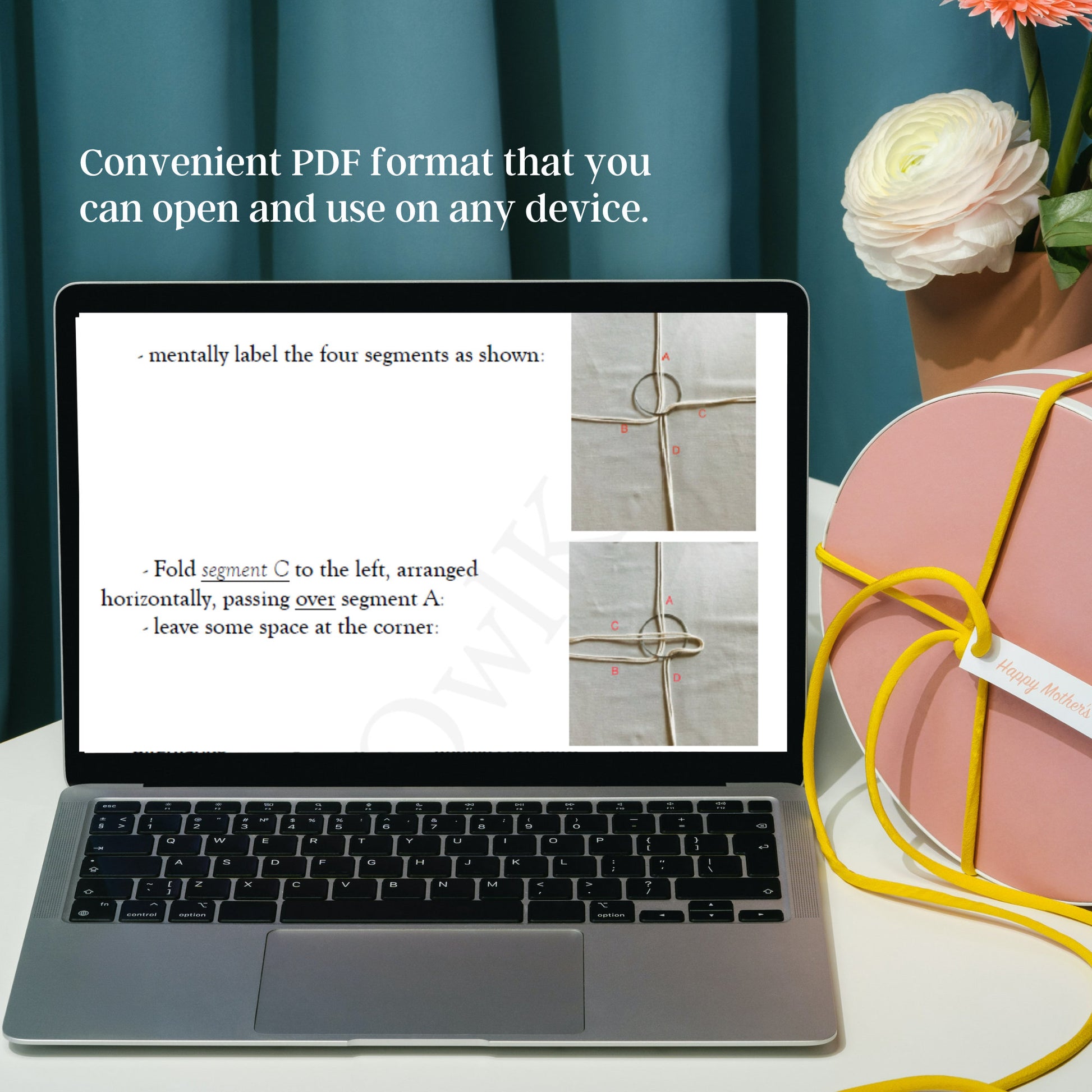 Laptop displaying a PDF on a desk with a decorative item and flowers in the background