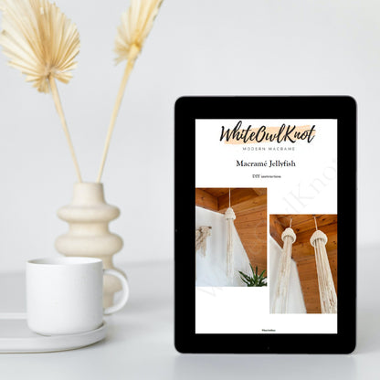 Tablet displaying a design app with 'WhiteOwlKnot' on a white surface with decorative elements.