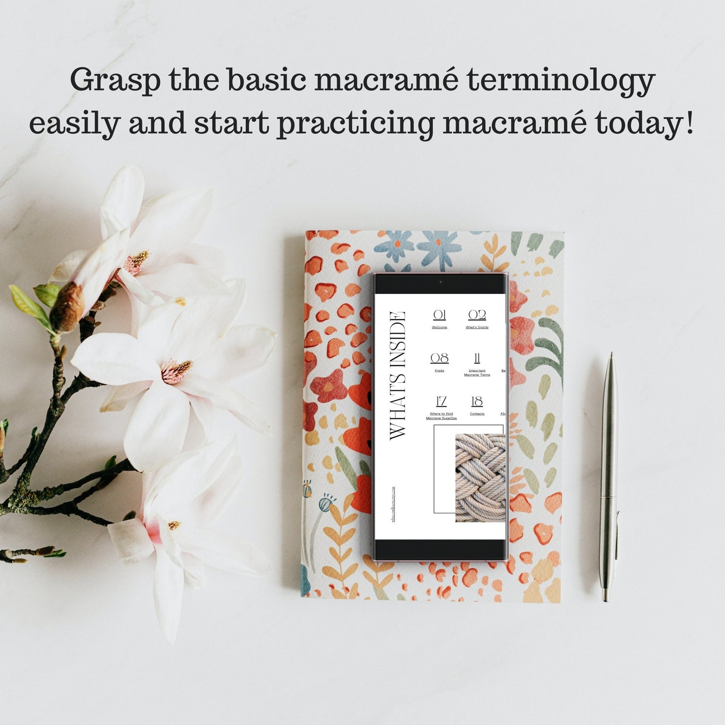 Floral notebook with a tablet on top, surrounded by flowers on a light background