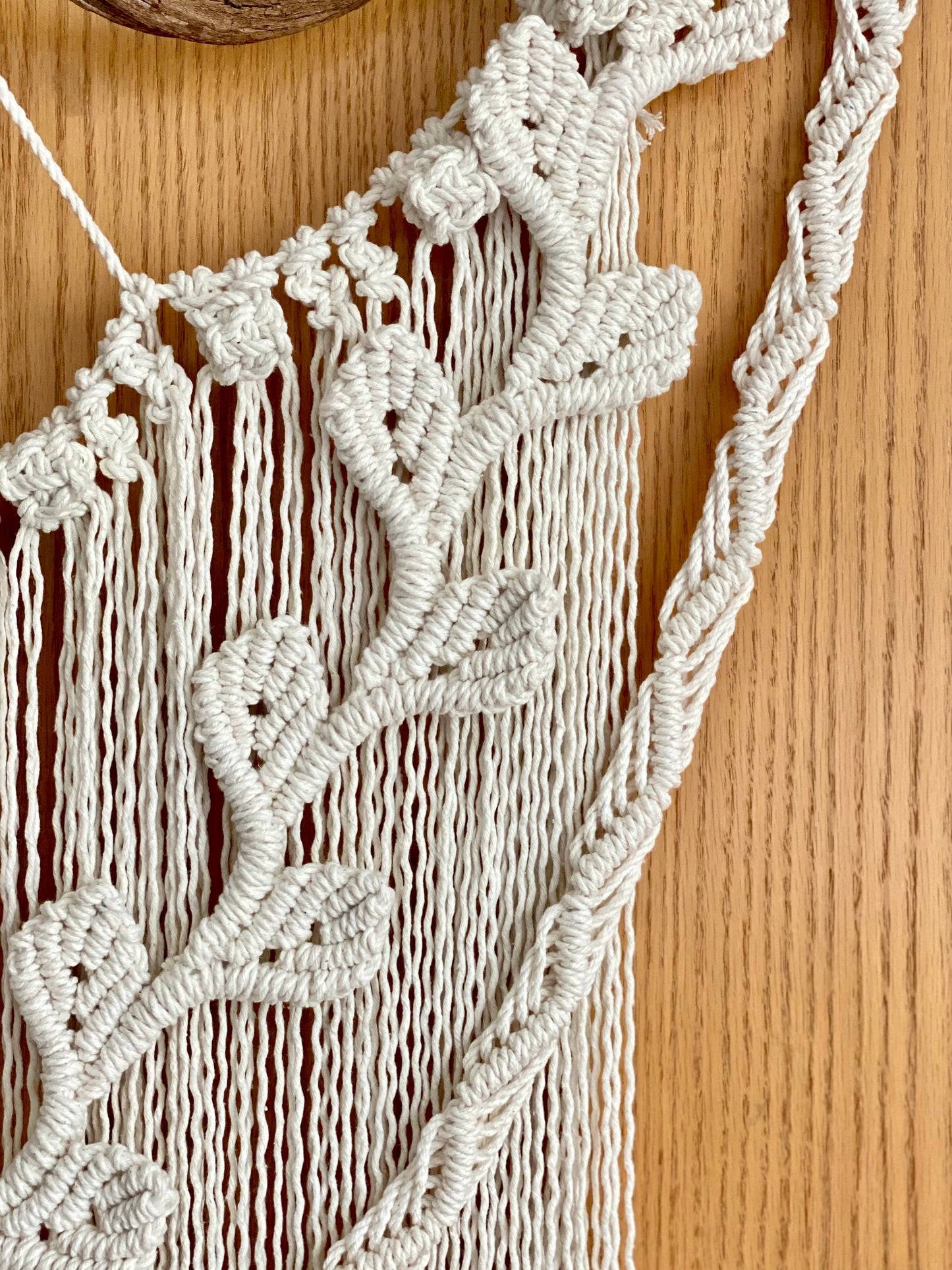 Close-up of a macrame wall hanging on a wooden surface