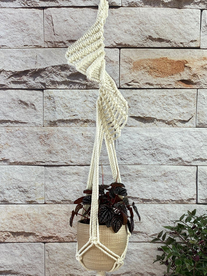Macrame plant hanger with a plant against a stone wall background