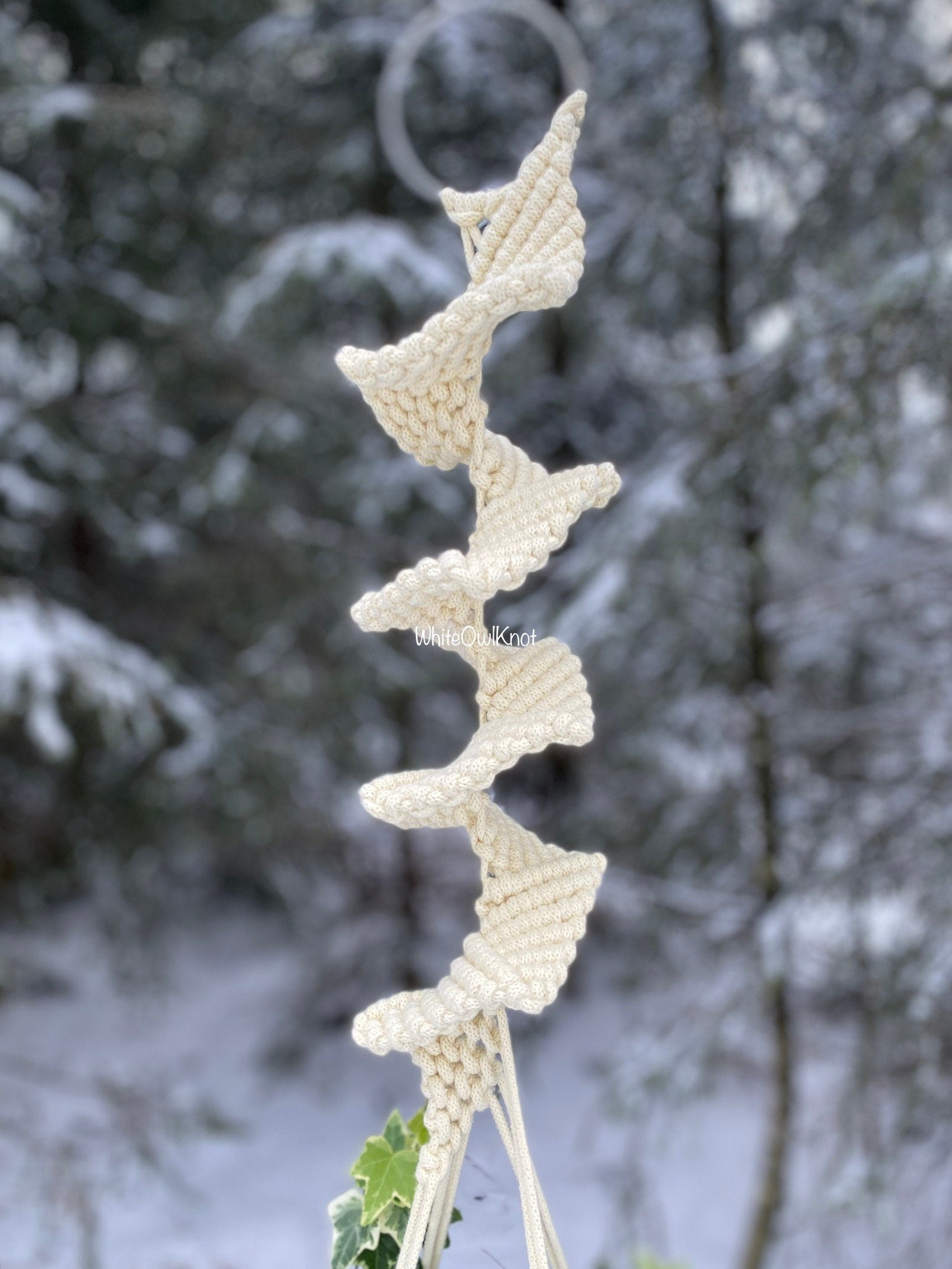 Knitted decorative item on a branch with a snowy background