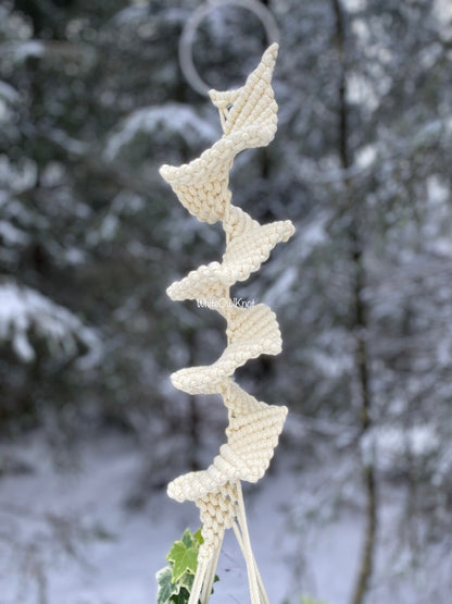 Knitted decorative item on a branch with a snowy background