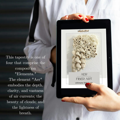 Person holding a tablet displaying fiber art design on a blurred background