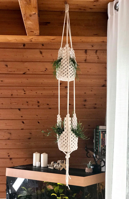 Macrame plant hangers with greenery against a wooden wall.