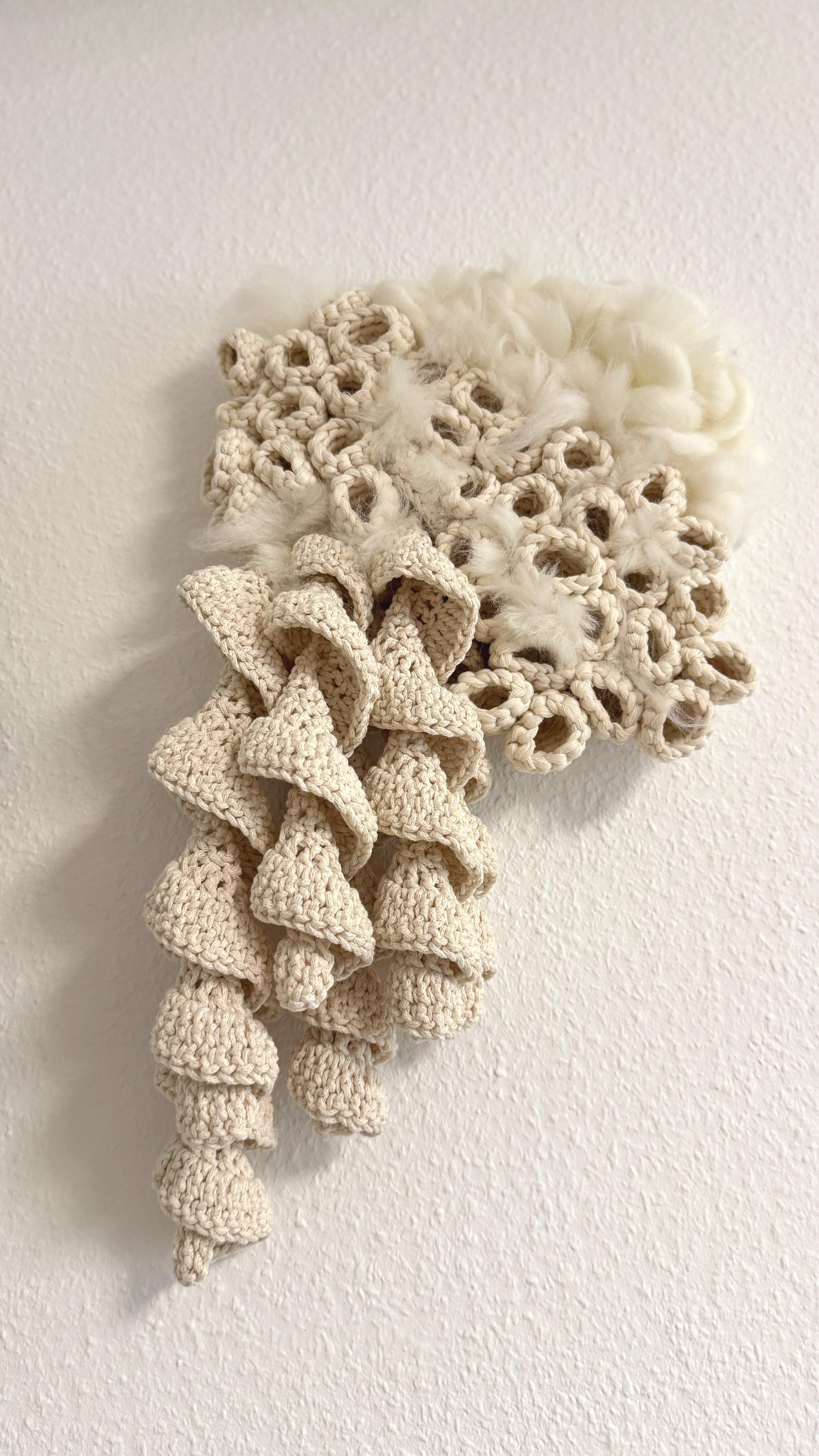 Textured beige wall art piece on a white background