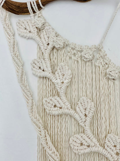 Macrame wall hanging with leaf patterns on a white background