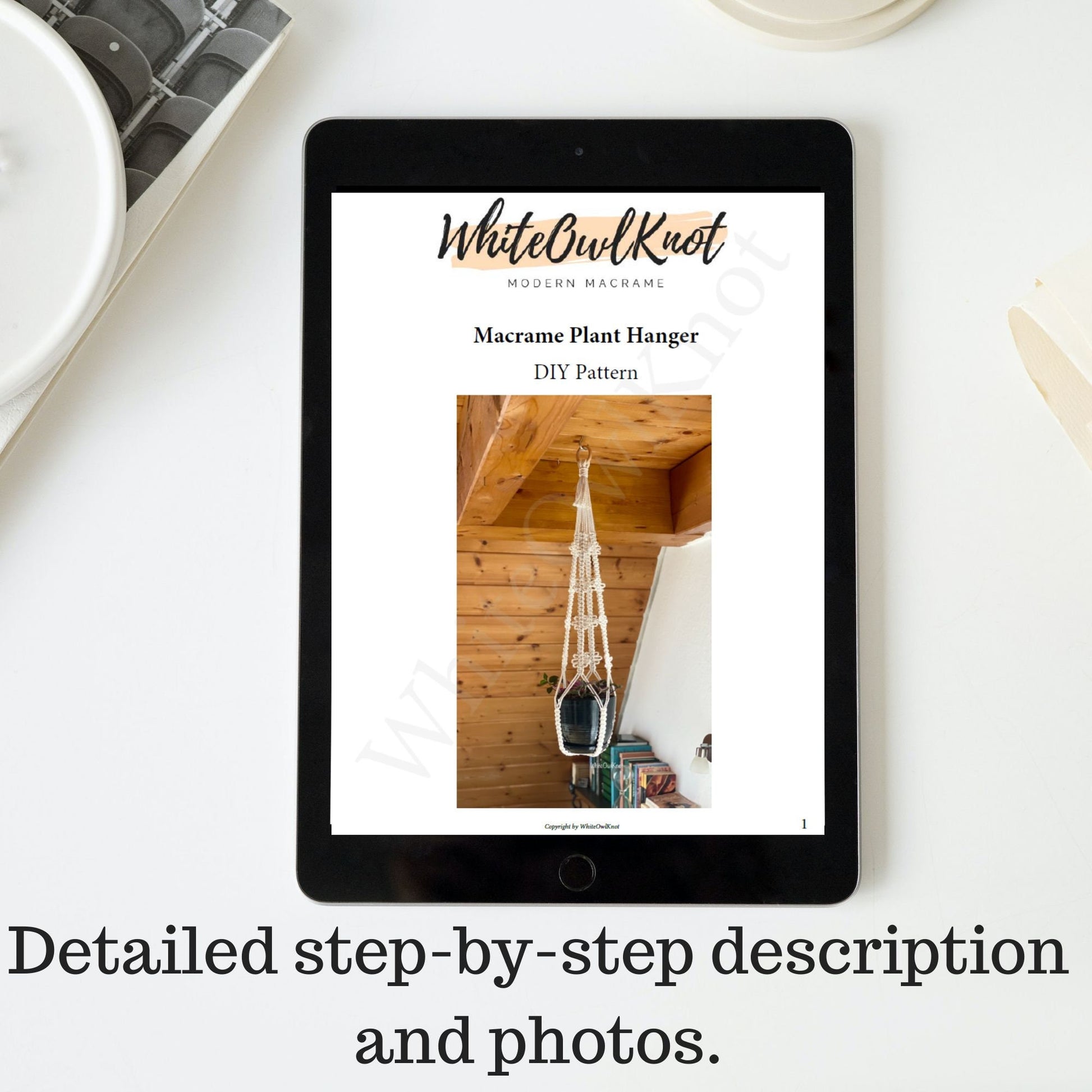 Tablet displaying a WhiteOwlKnot macrame plant hanger DIY pattern on a white surface.