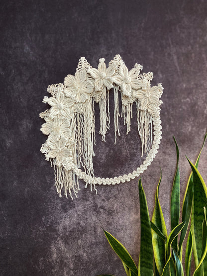 Decorative headband with floral details on a textured dark background