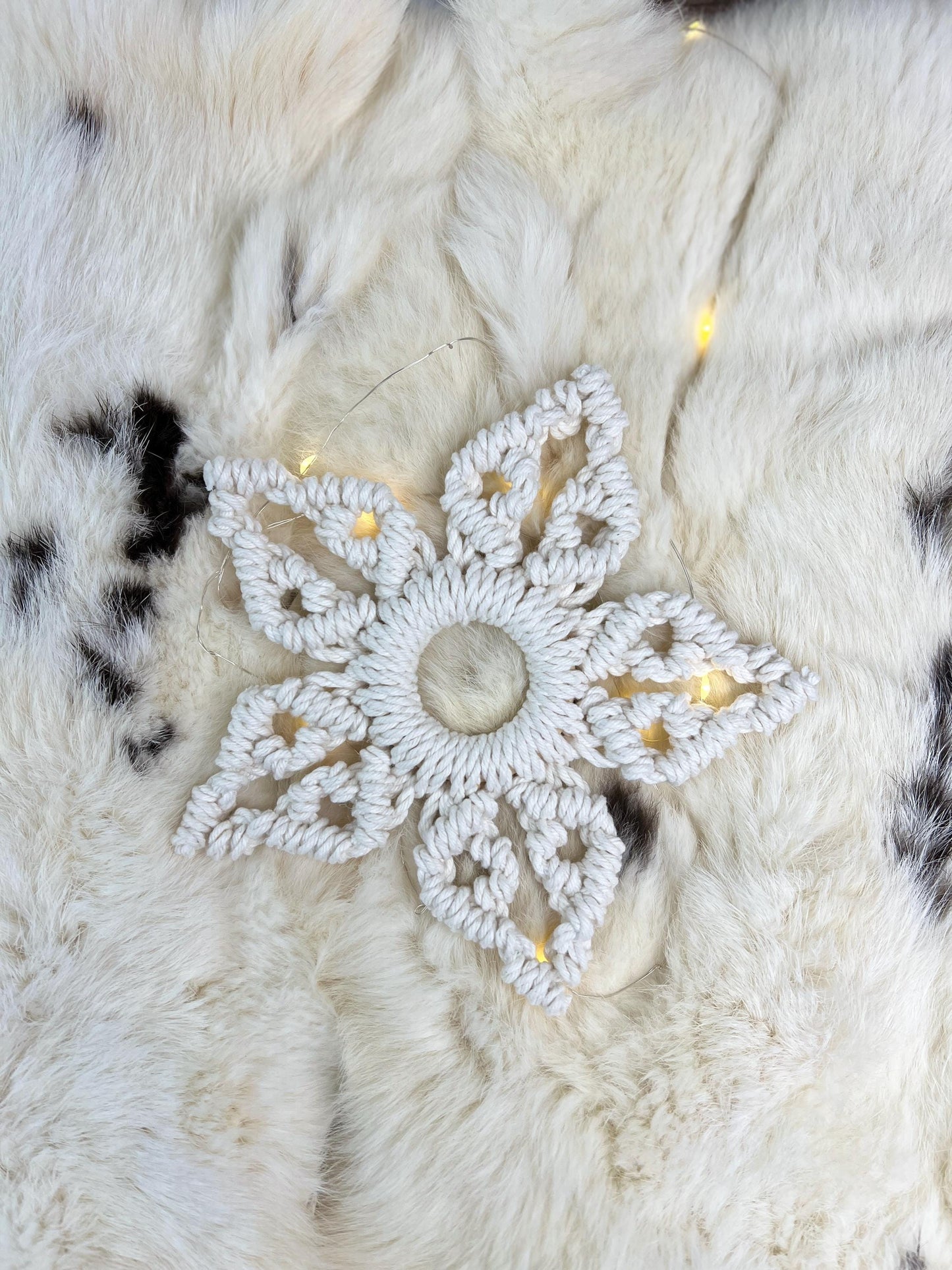 Decorative white snowflake ornament on a textured white surface