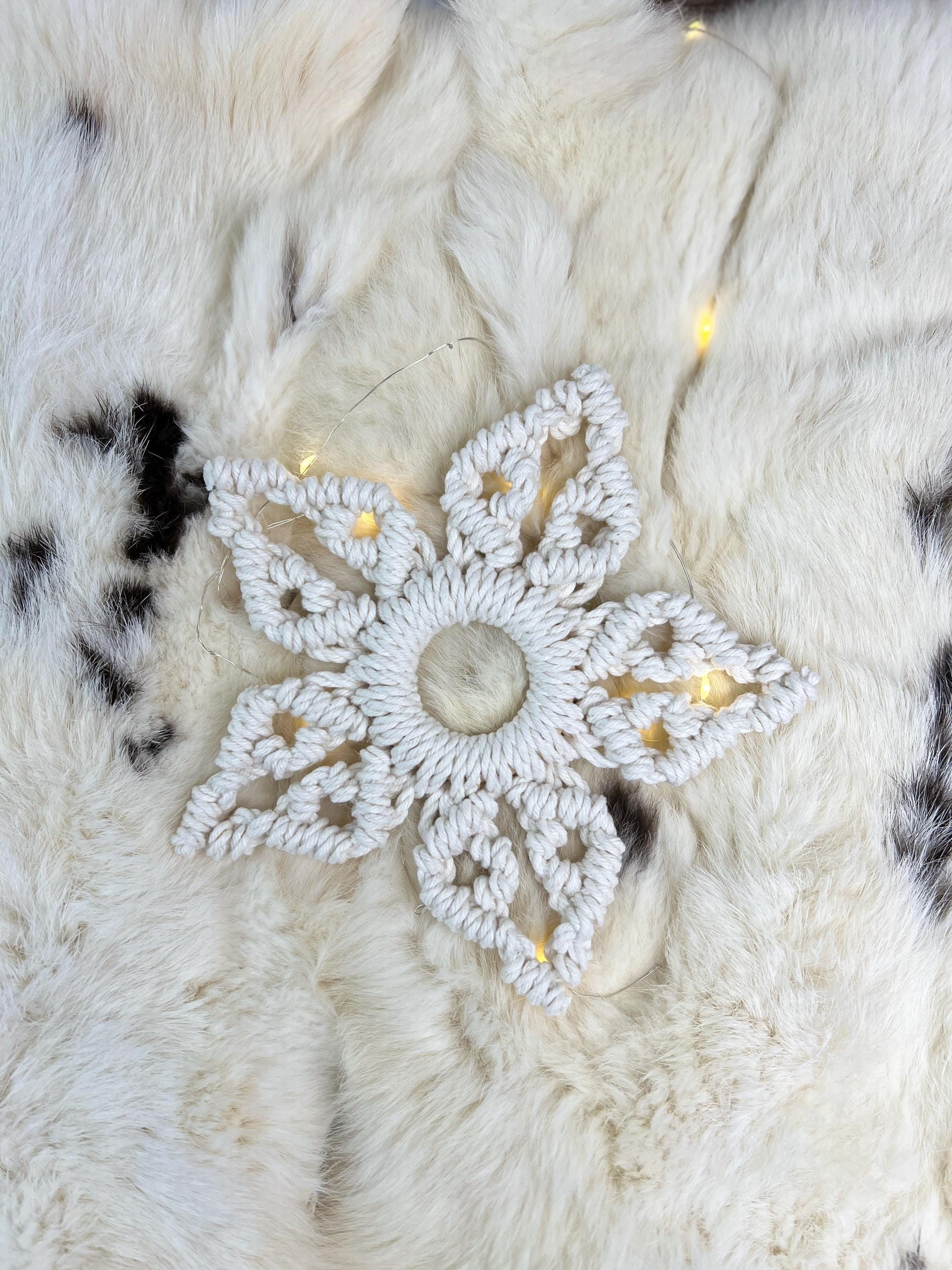 Decorative white snowflake ornament on a textured white surface