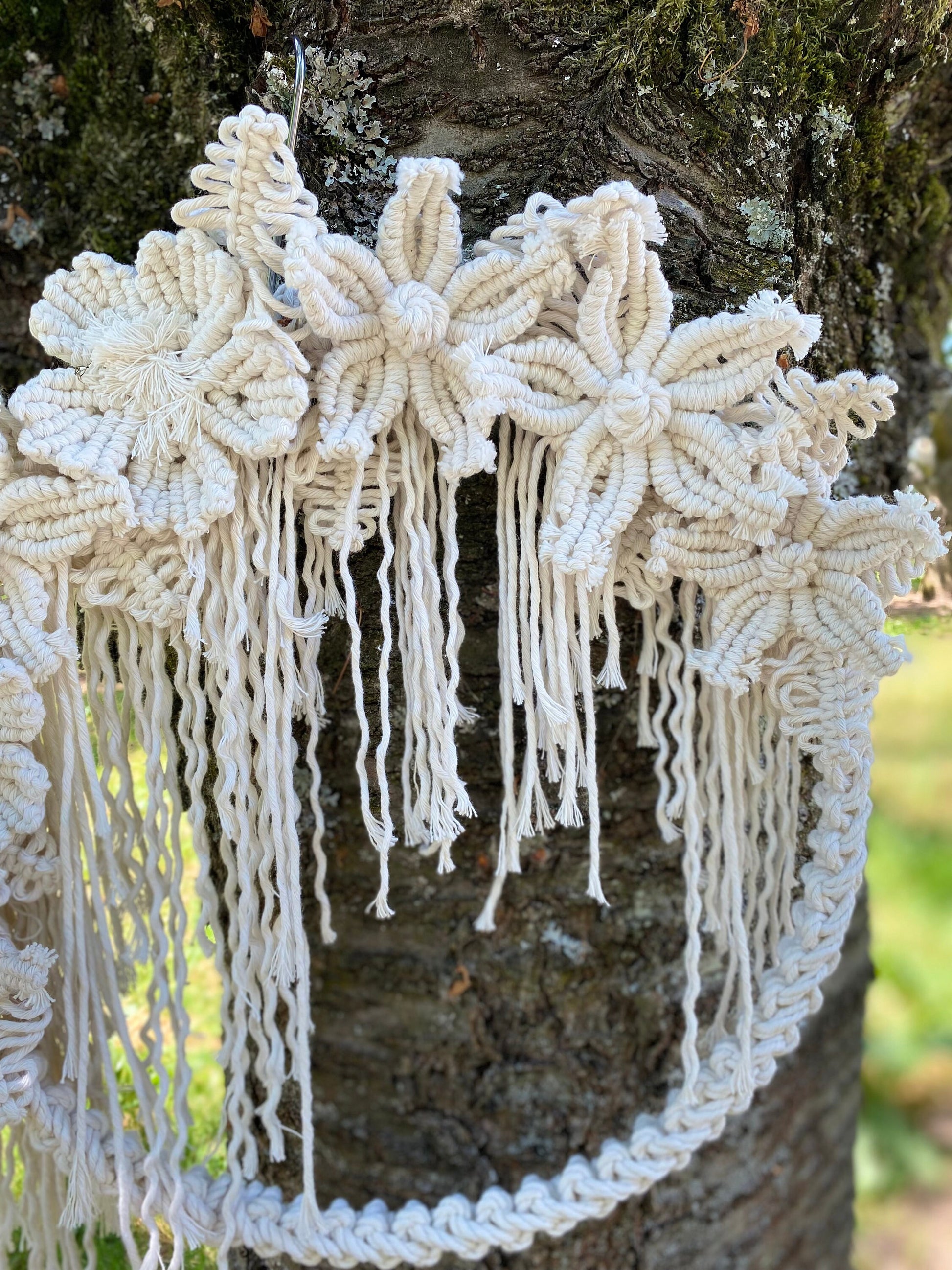 Decorative white lace hanging against a tree trunk