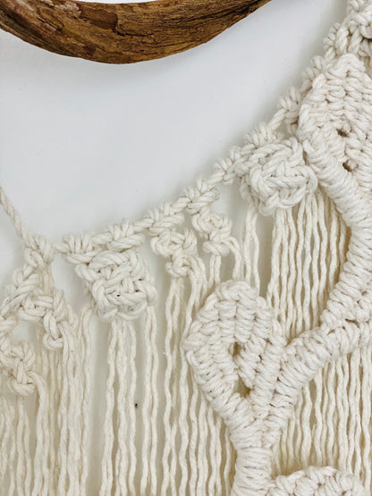 Close-up of a macrame wall hanging with intricate patterns and tassels.