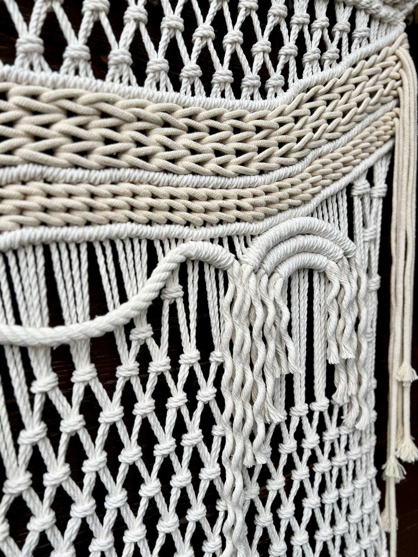 Close-up of a macrame wall hanging with intricate patterns and tassels.