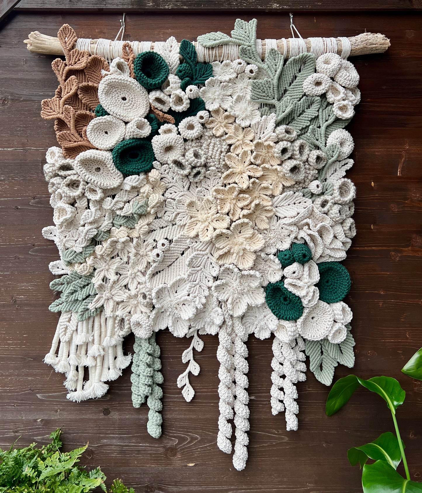 Fiber art floral coral reef wall hanging on a wooden surface