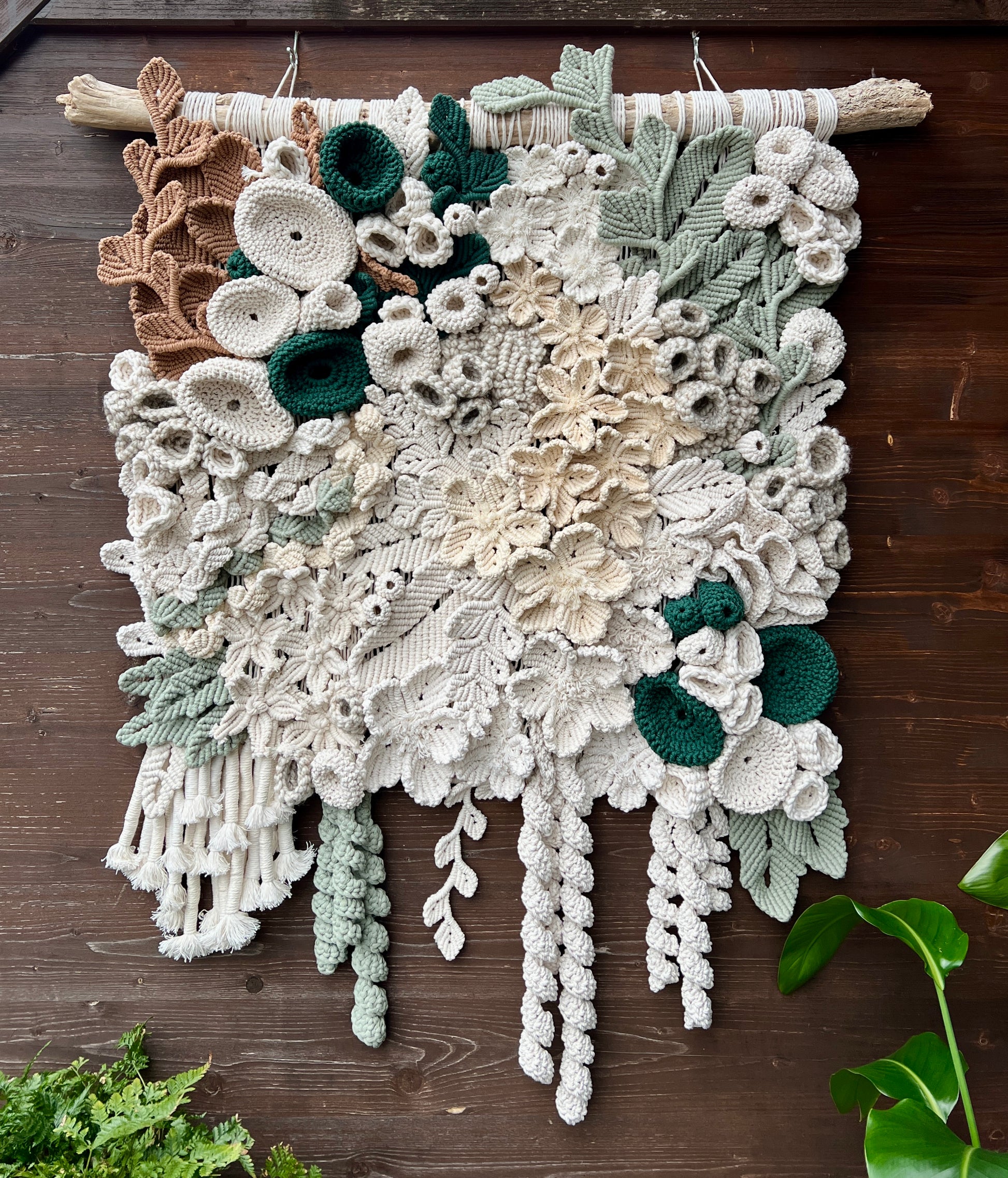 Fiber art floral coral reef wall hanging on a wooden surface