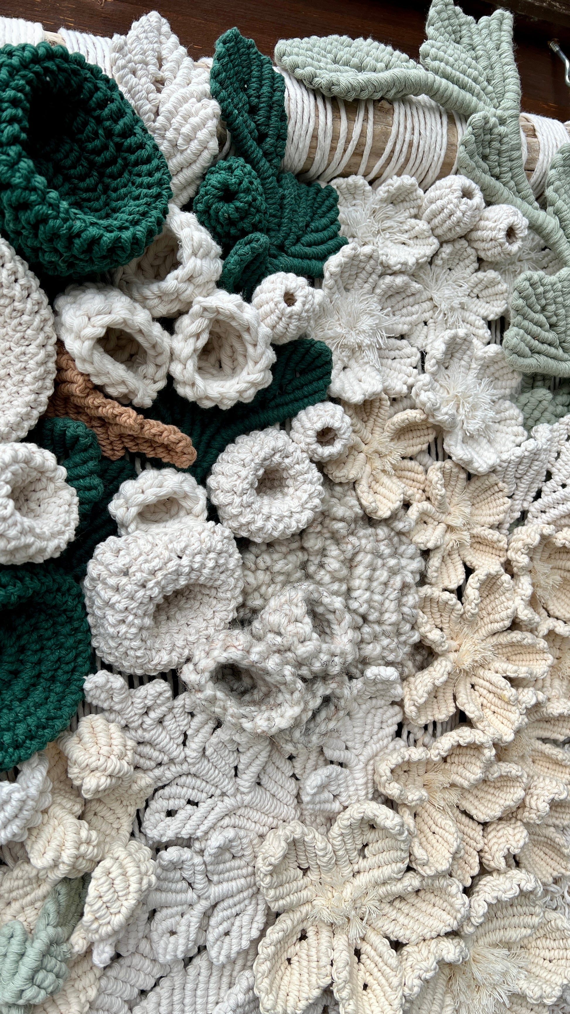 Close-up of textured fabric with floral patterns in green, white, and beige.