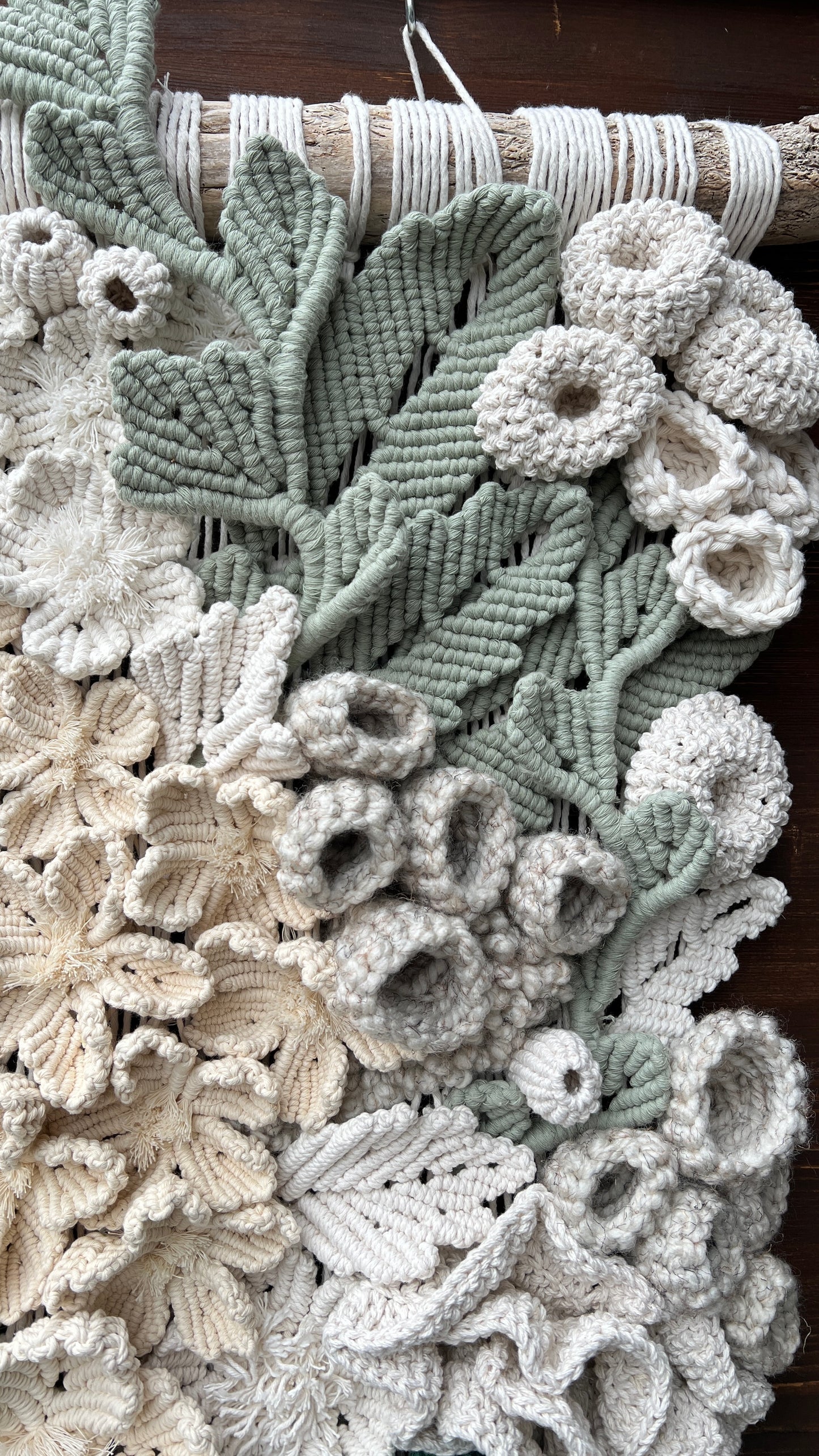 Close-up of a textured fabric with floral patterns and coral reef details in shades of green and beige.