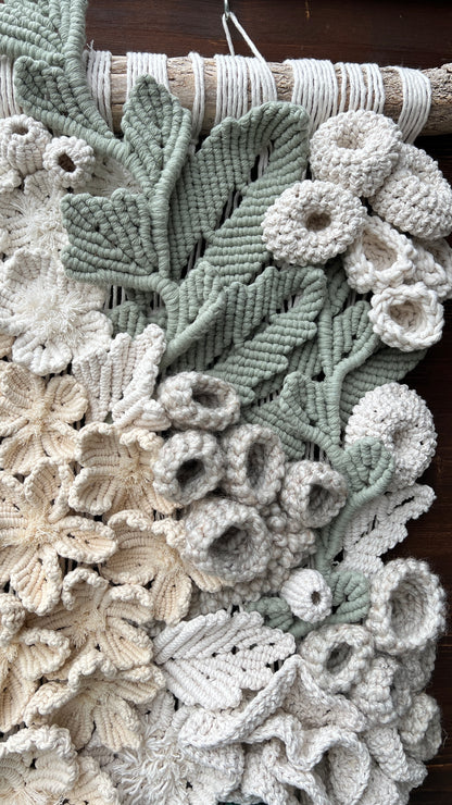 Close-up of a textured fabric with floral patterns and coral reef details in shades of green and beige.