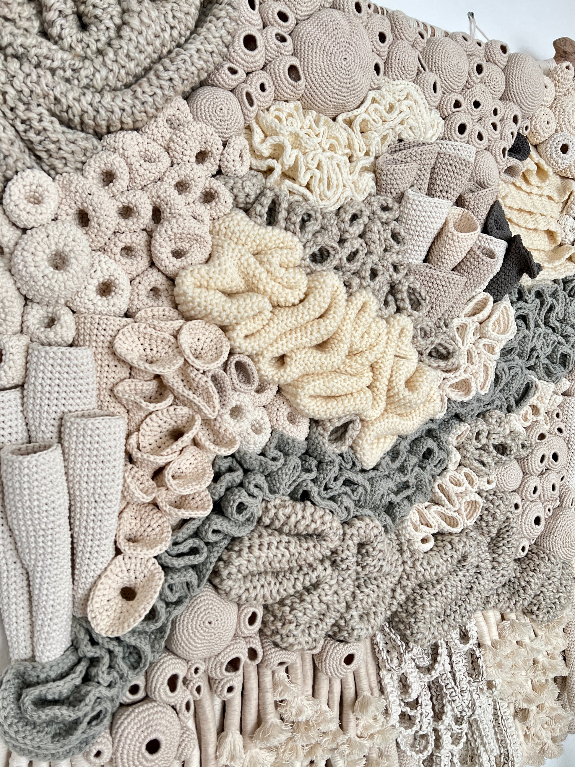 Close-up of a textured crochet fabric with various patterns and colors.