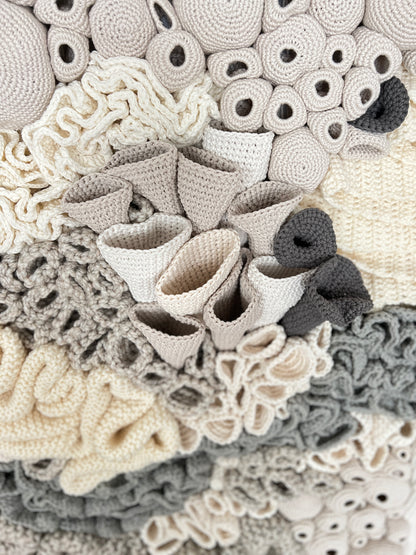 Close-up of textured crochet art details in neutral colors