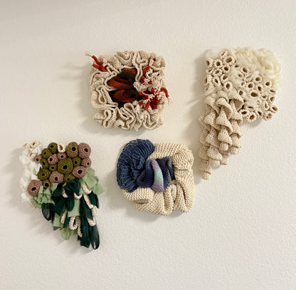 Four textured wall art pieces in various patterns and colors on a white background