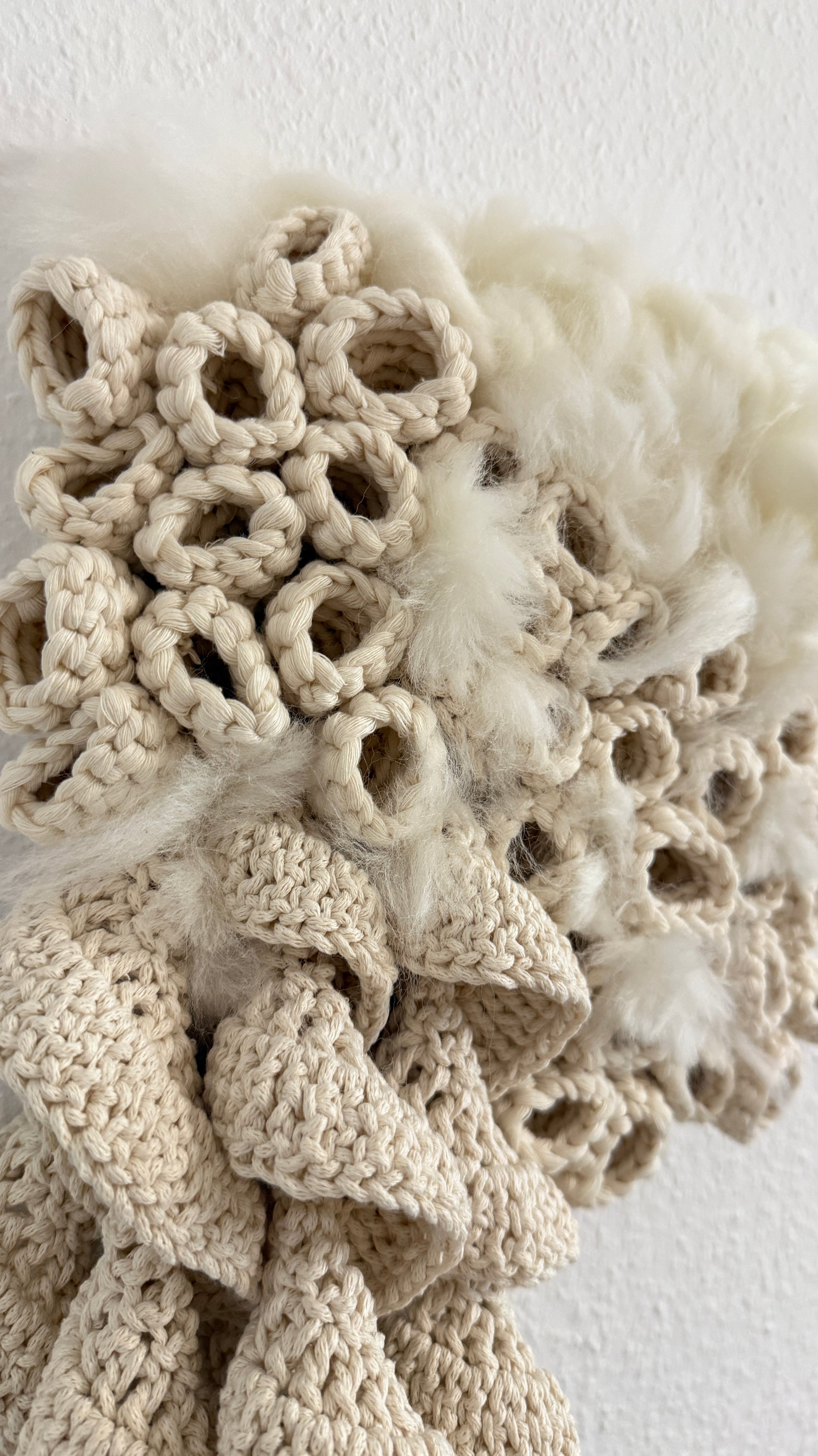 Close-up of a textured beige fabric with floral patterns on a light background