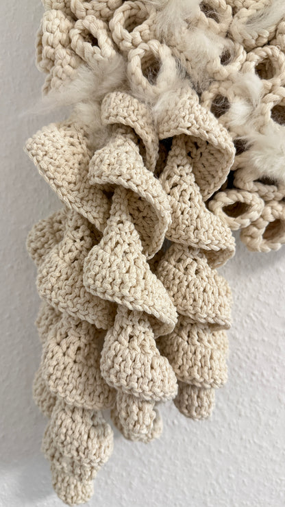 Textured beige crochet fabric on a textured white background