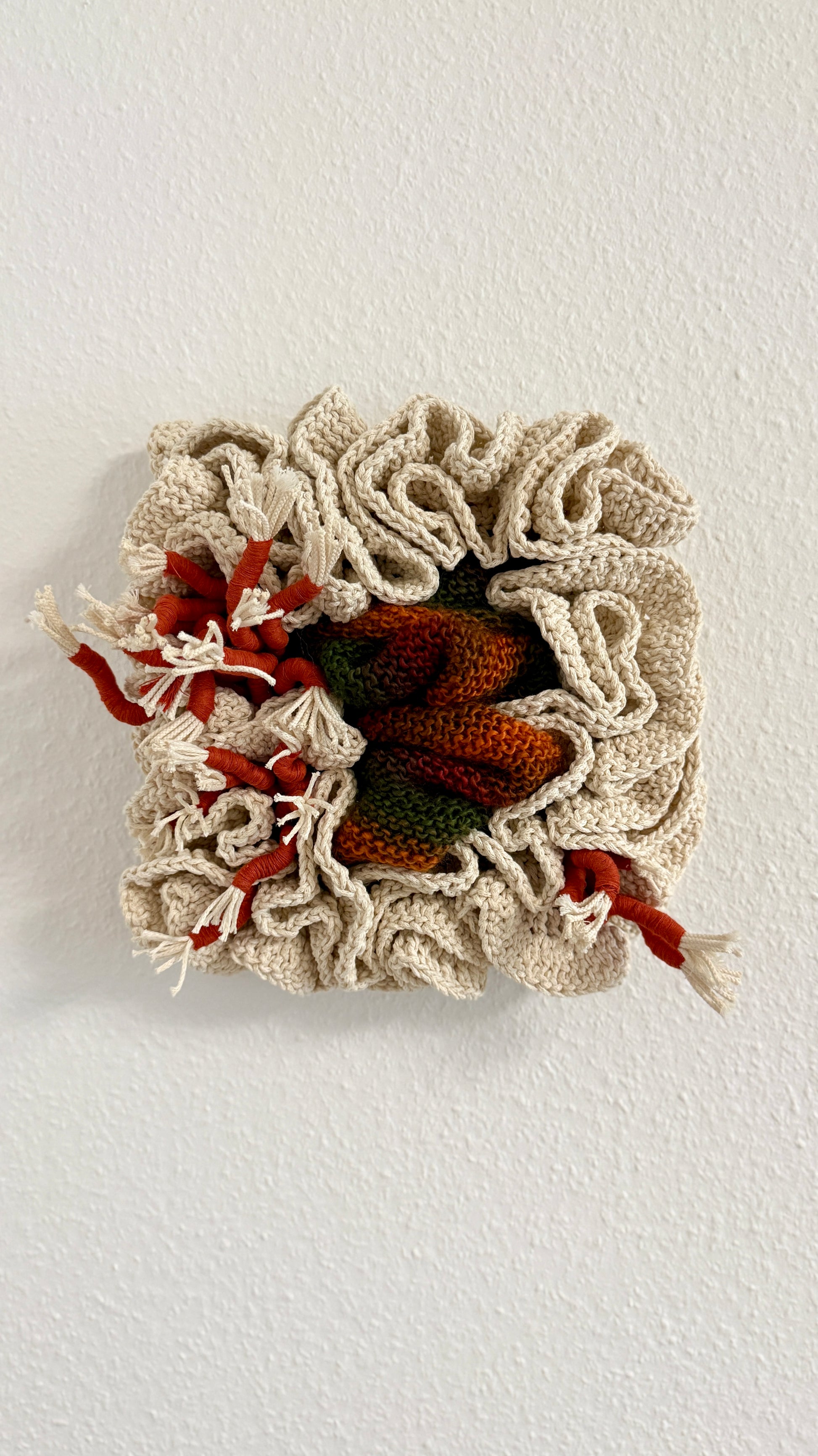 Crocheted wall art piece with autumn leaf design on a white background