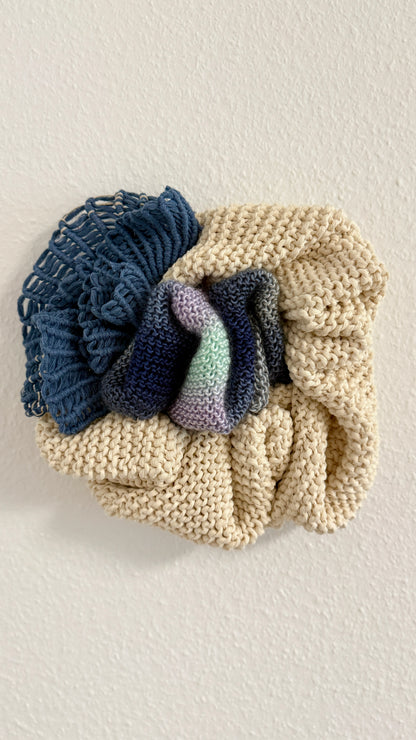 Knitted wall hanging with blue and purple gradient on a light background