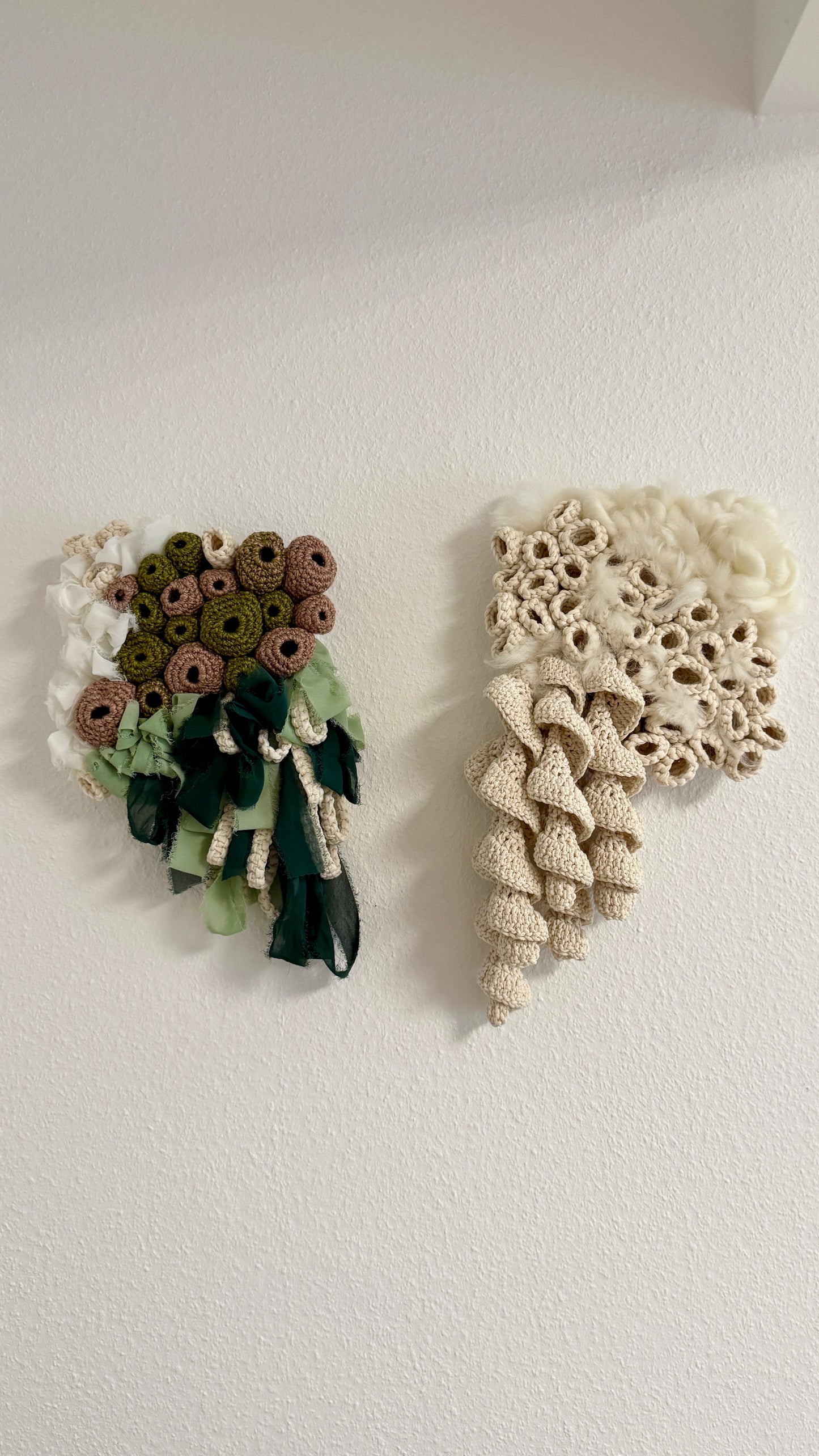 Two decorative wall hangings, one floral and one with a textured pattern, on a white background.
