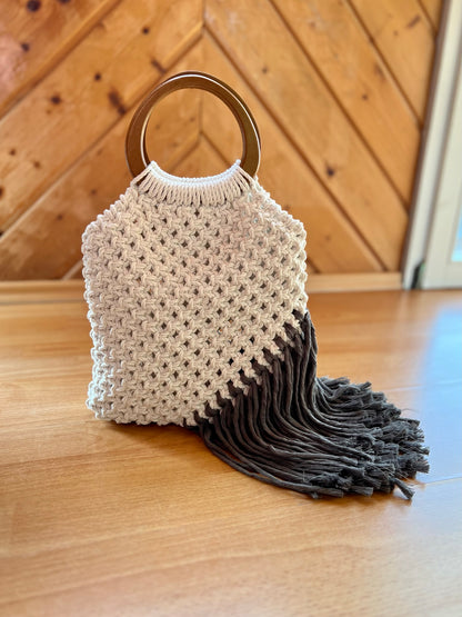 Macrame handbag with wooden handle on a wooden floor