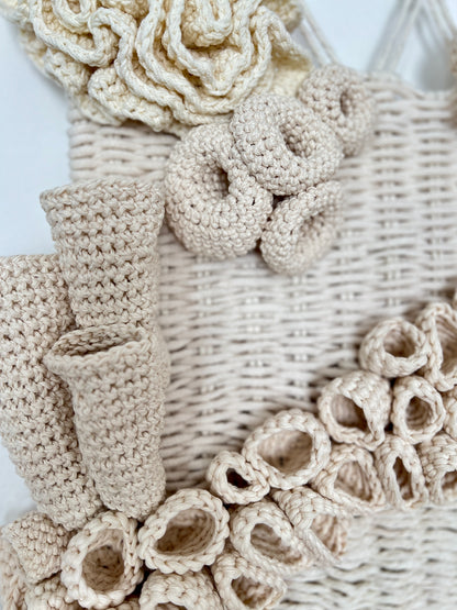 Close-up of beige crochet flowers and decorative elements on a white background