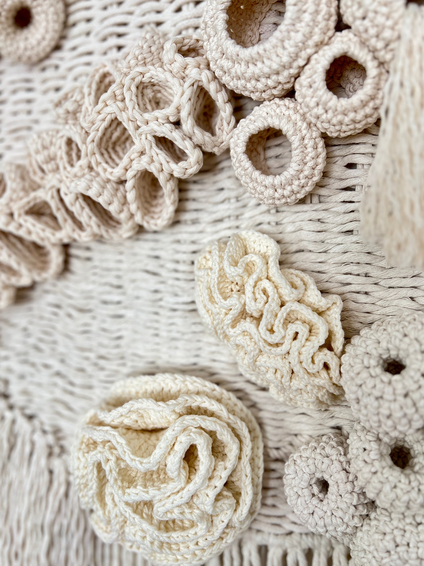 Close-up of beige crochet patterns on a textured fabric background