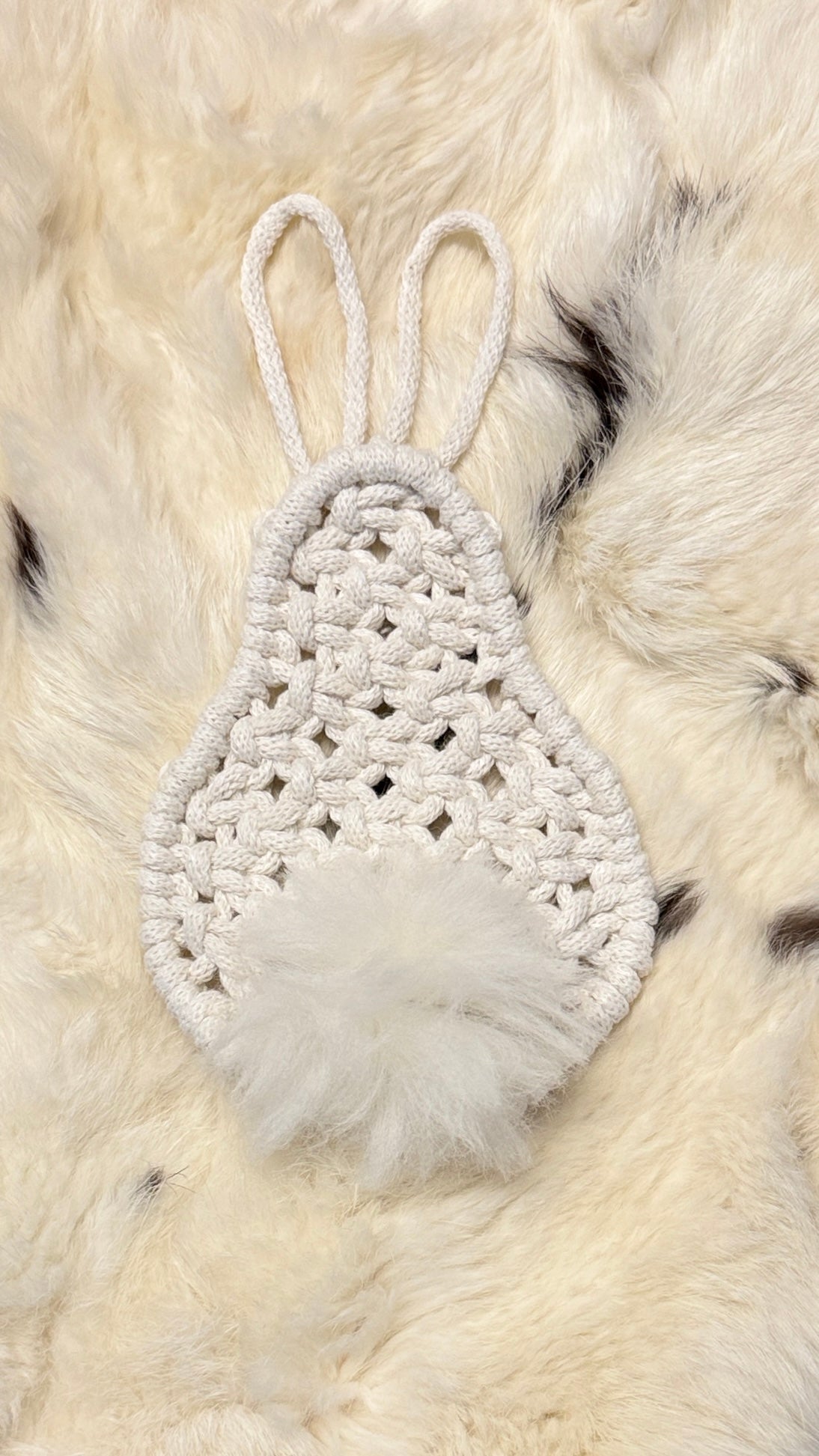 Macrame bunny ornament with feathers on a fur background