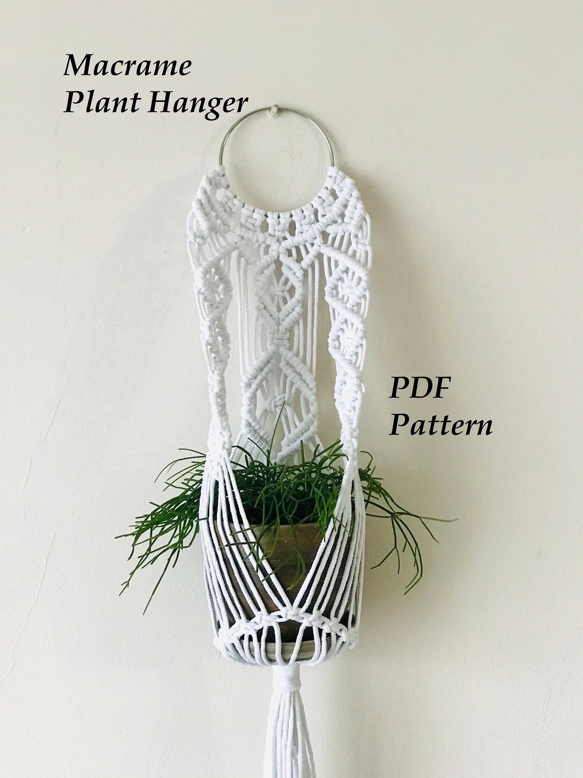 White macrame plant hanger with a plant on a plain background, labeled 'Macrame Plant Hanger' and 'PDF Pattern'.
