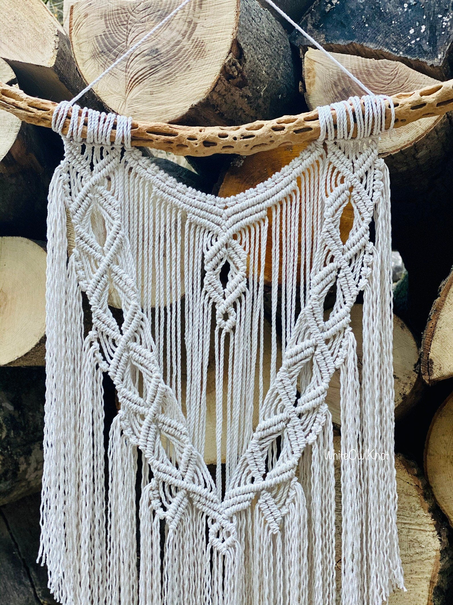 Macrame wall hanging on a wooden log background