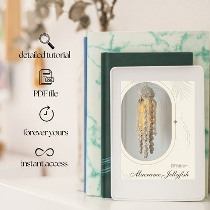 Marble-patterned book with a macrame jellyfish pattern on a white surface.