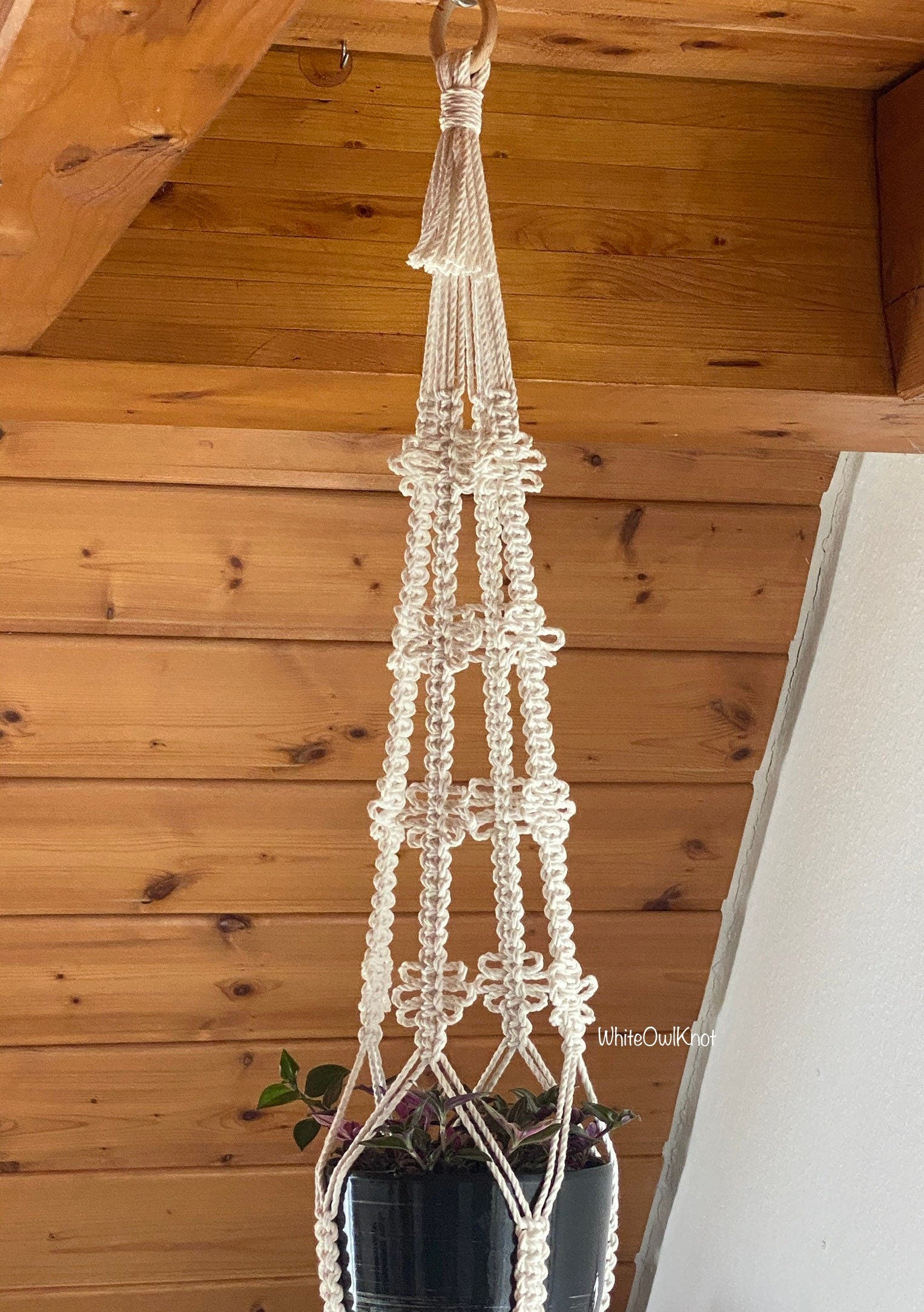 Macrame plant hanger with a wooden ceiling background