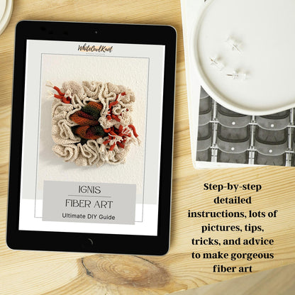 Tablet displaying a fiber art guide on a wooden surface with a yarn ball and knitting needles.